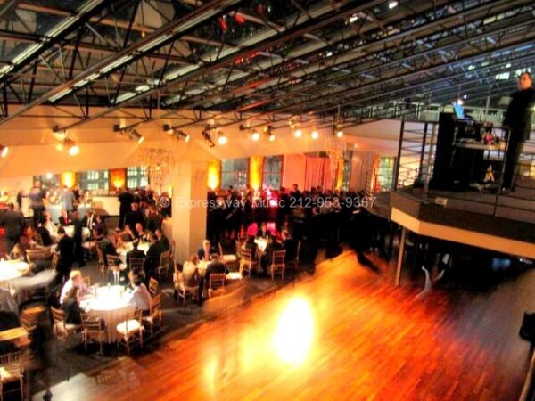 The DJ booth on the balcony above dinner tables and the dance floor at Tribeca Rooftop
