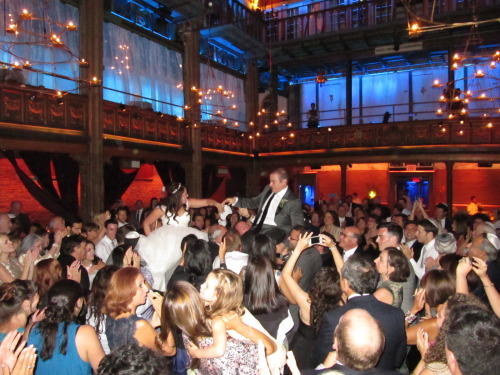 Bride and Groom being lifted on chairs during Hora