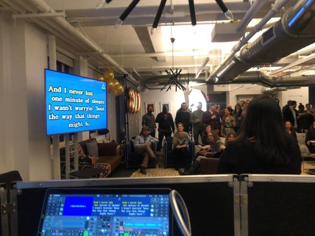 employees sing karaoke of large screen tv from expressway music nyc