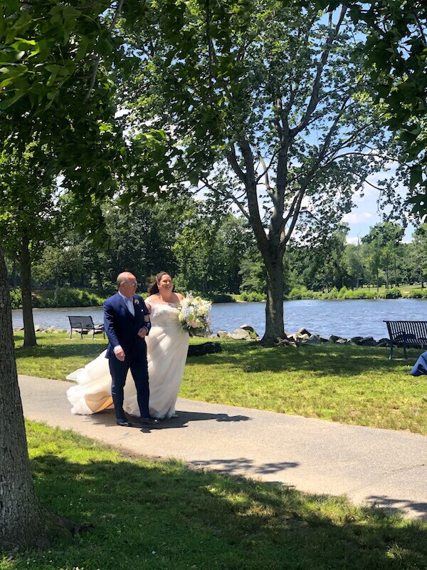 Father walking Bride down aisle by Lake to be married